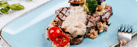 Carbon steel steak with shallot gravy on plate
