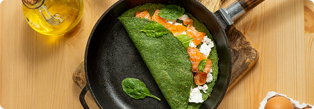 Non-stick omelette with herbs in yellow pan