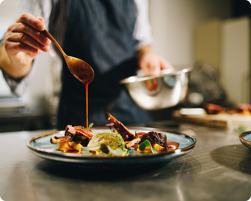 Chef preparing a dish with sauce