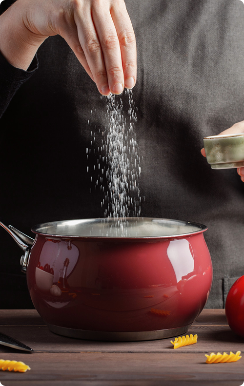 Adding salt to red cooking pot